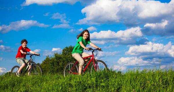 Dospívající dívka a chlapec na kolech — Stock fotografie