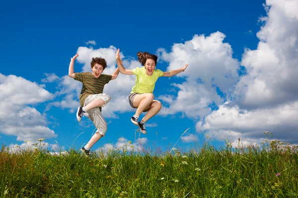 Menina e menino pulando — Fotografia de Stock
