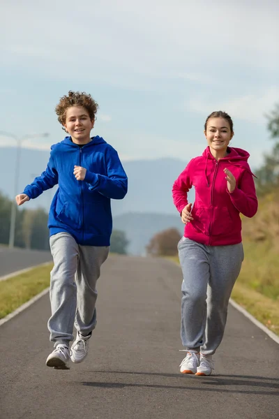 Mädchen und Junge im Teenageralter rennen — Stockfoto