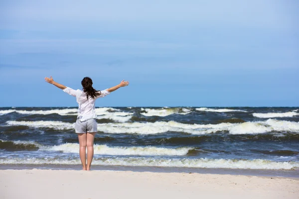 Flicka stående på stranden — Stockfoto