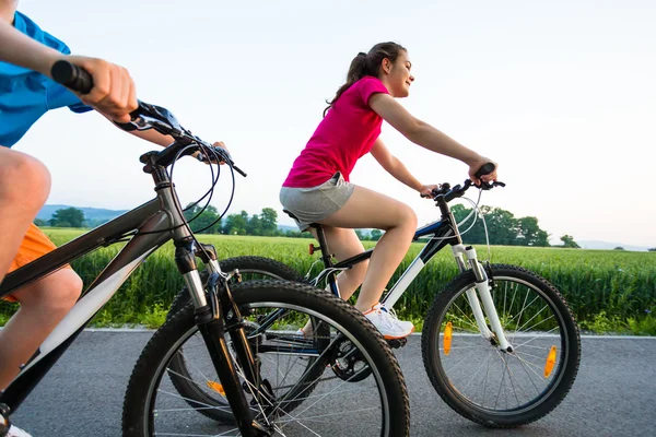 Chica adolescente y niño montando bicicletas — Foto de Stock