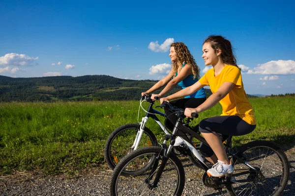 Dos mujeres jóvenes en bicicleta — Foto de Stock