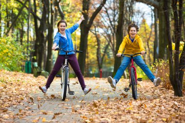 Teens and bikes in city park clipart