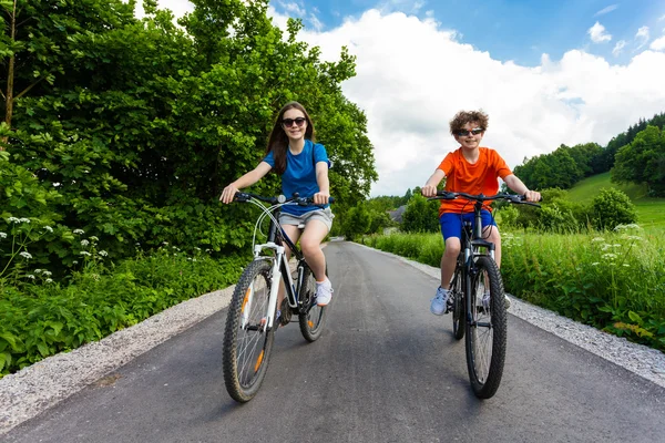 Chica adolescente y niño montando bicicletas — Foto de Stock