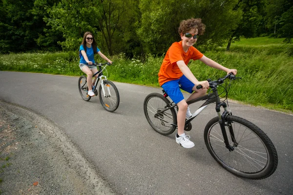 Tiener meisje en jongen paardrijden fietsen — Stockfoto