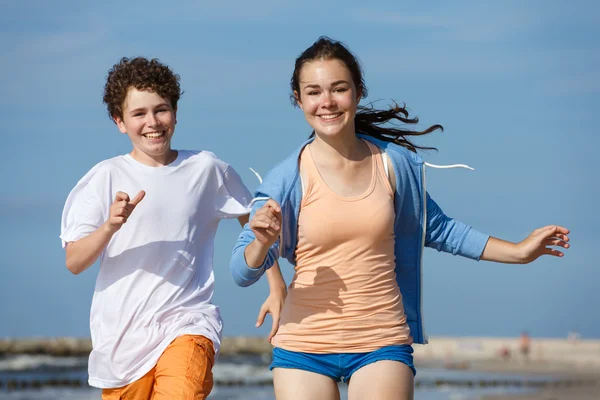 Adolescente chica y chico corriendo — Foto de Stock