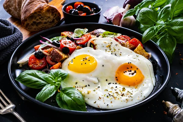 Sunny side up eggs with panzanella salad on wooden table