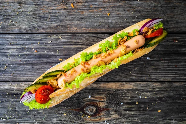 Hot Dog Μπαγκέτα Λουκάνικο Και Φρέσκα Λαχανικά Ξύλινο Τραπέζι — Φωτογραφία Αρχείου