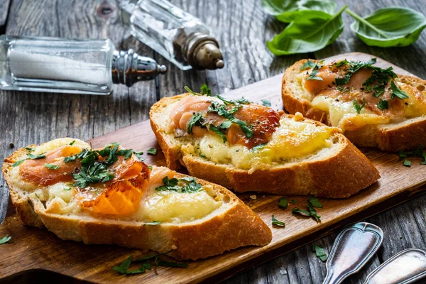 Sanduíches Saborosos Pão Assado Com Mussarela Salmão Salsa Mesa Madeira — Fotografia de Stock