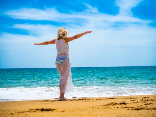 在阳光明媚的海滩上行走的女人 — 图库照片