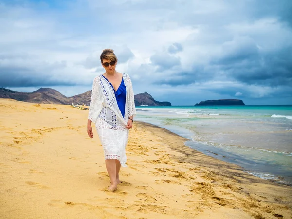 中年女性がビーチを歩く — ストック写真