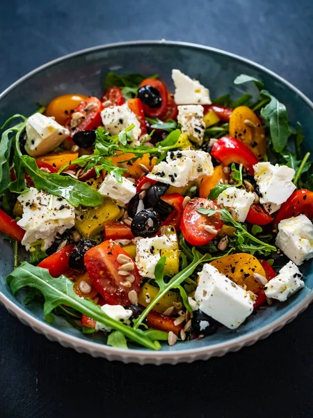 Fresh vegetable salad with feta cheese on wooden table