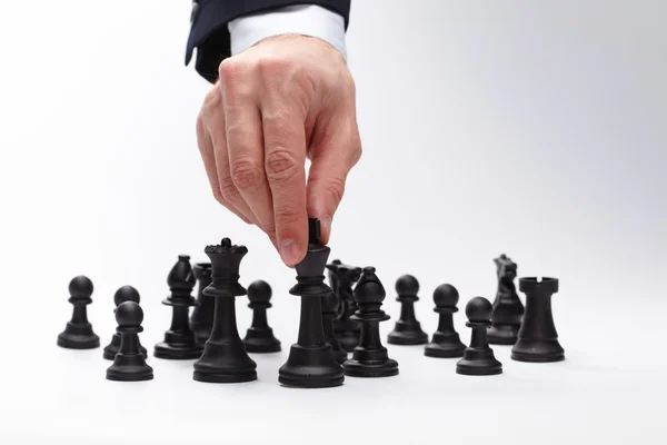 Business man moving chess figure. Isolated on gray — Stock Photo, Image