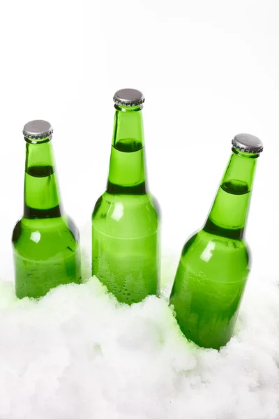 Garrafas de cerveja na neve. Isolado em branco — Fotografia de Stock