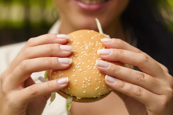 Kvinne som spiser hamburger – stockfoto