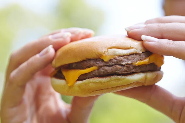 Žena jíst hamburger — Stock fotografie