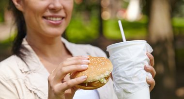 Hamburger ve kokteyl yemek kadın