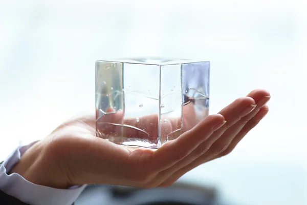 Glas cube i handen — Stockfoto