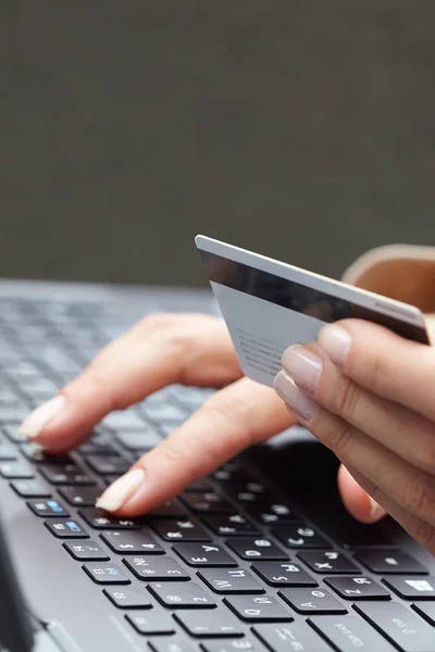 Frau hält Kreditkarte auf Laptop — Stockfoto