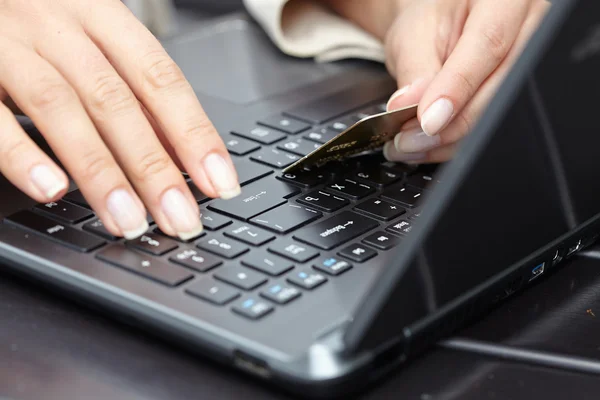 Frau hält Kreditkarte auf Laptop — Stockfoto