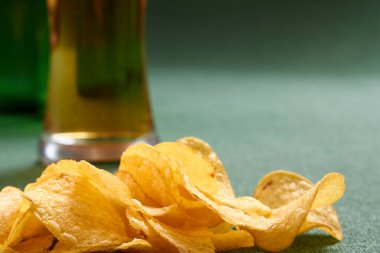 Bira bardağının yanında patates cipsi yığını, yakın görüş.