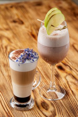 ahşap masa üzerinde süt köpüğü ile kahve sanatı