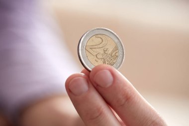 Closeup of man hand holding coin isolated on white background