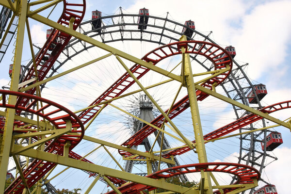 Roller coaster and large ferris wheel in Prater, Vienna, Austria