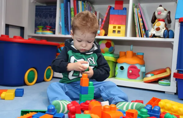 Een jongetje spelen met plastic blokken — Stockfoto