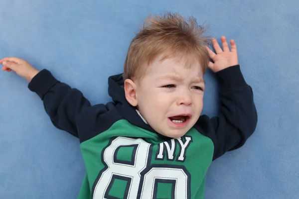 Ein kleiner Junge weint auf einem Fußboden — Stockfoto