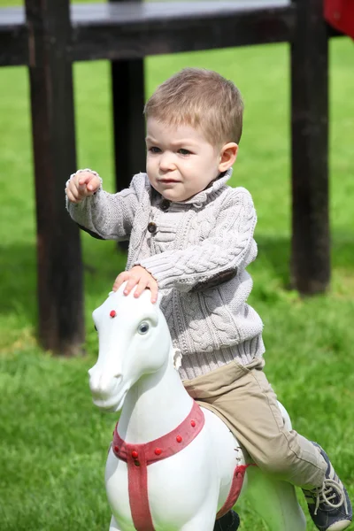 Мальчик 2 лет играл с лошадью — стоковое фото