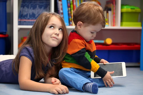 Disappointing girl with her little brother using a tablet comput — Stock Photo, Image