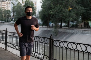 Şehirde koşan Asyalı bir adam, akşam vakti. Kazakistan