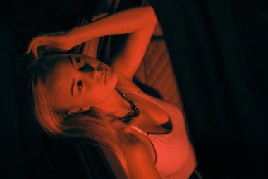 Avrupa görünümlü güzel bir kız arabada yolcu koltuğunda oturur ve pencereye bakar.