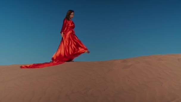Asijka v červených šatech tančící na písečných dunách — Stock video