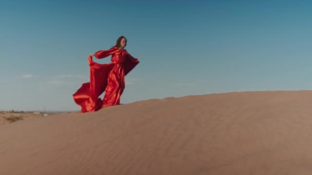 Eine Asiatin im roten Kleid tanzt auf Sanddünen — Stockvideo