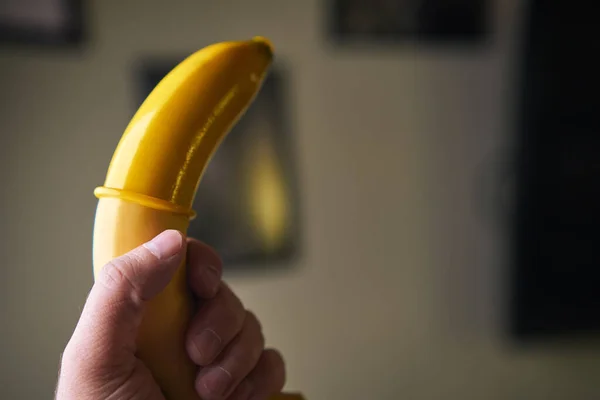 Condón Amarillo Plátano Amarillo Sosteniendo Una Mano Masculina Interior — Foto de Stock