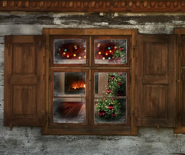 Christmas lights seen through a wooden cabin window — Stock Photo