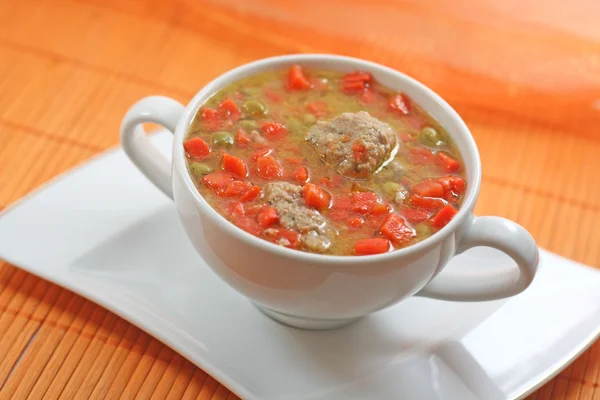 Home-made meatballs and vegetable soup, in a white soup cup — Stockfoto