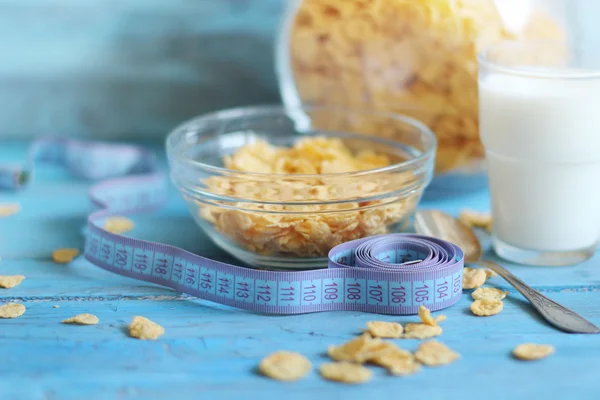 Cornflakes in Schüssel mit Milch auf blauem Holzhintergrund. — Stockfoto