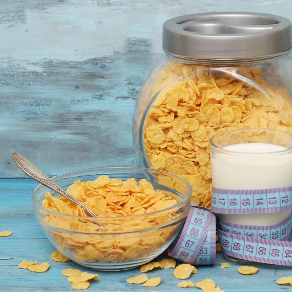 Cornflakes in Schüssel mit Milch auf blauem Holzhintergrund. — Stockfoto