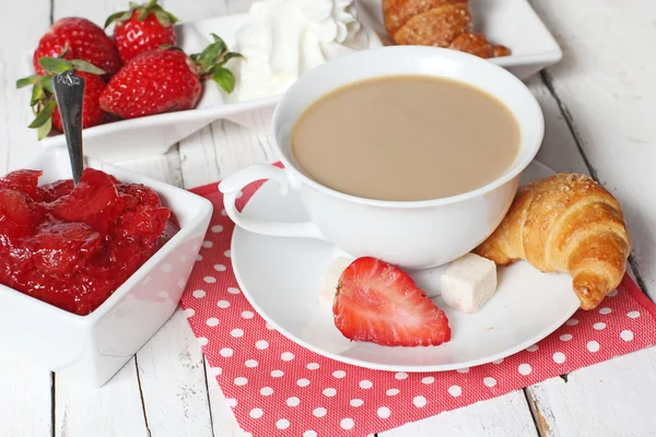 Frukost med croissanter, jordgubbe och kopp kaffe på vit — Stockfoto