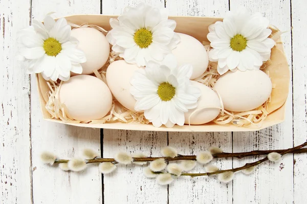 Uova di Pasqua con fiori su sfondo di legno — Foto Stock