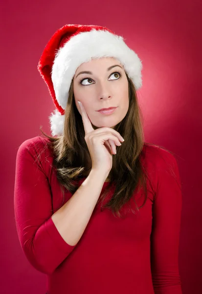 Hermosa joven con sombrero de santa pensando — Foto de Stock