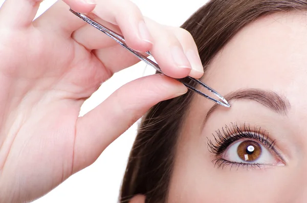 Young Woman Tweezing Her Eyebrows Stock Picture