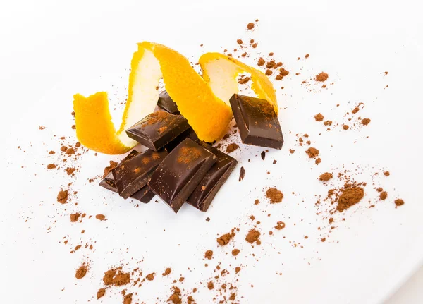 Gebrochene dunkle Schokolade mit Orangenschale — Stockfoto