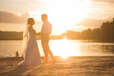 Yeni evli çift gün batımı ile Nehri üzerinde