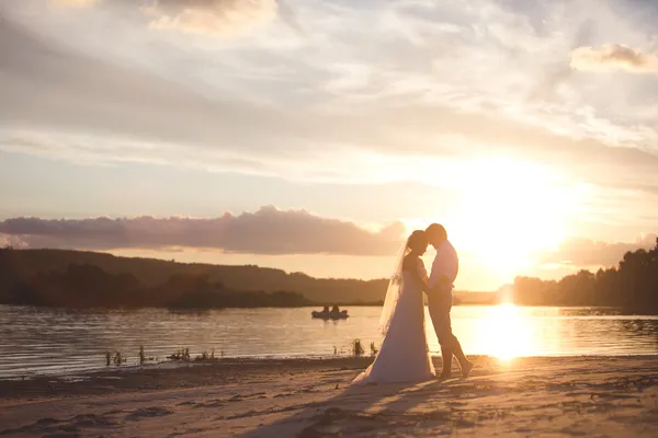 Pareja recién casada en el río con puesta de sol —  Fotos de Stock