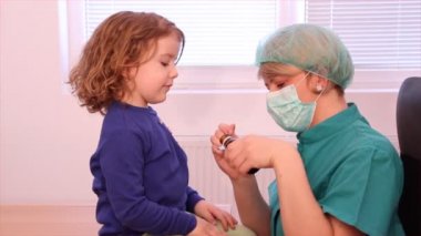 kadın doktor küçük bir kız bir ilaç verir.