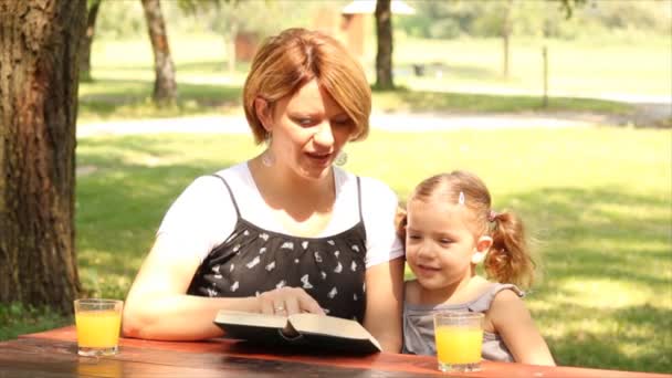 Mor och dotter läser en bok — Stockvideo
